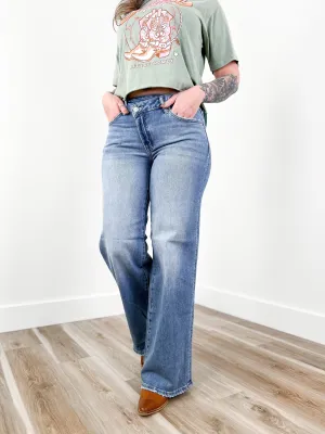 Risen Mid Rise Medium Wash Wide Leg Crossover Jeans